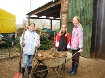 Bild: Die Kinder bei der Stallarbeit.